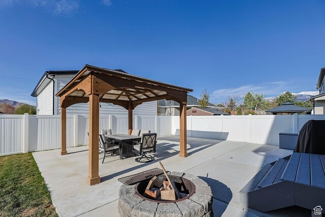 view of patio / terrace with a fenced backyard, a gazebo, a fire pit, and outdoor dining area