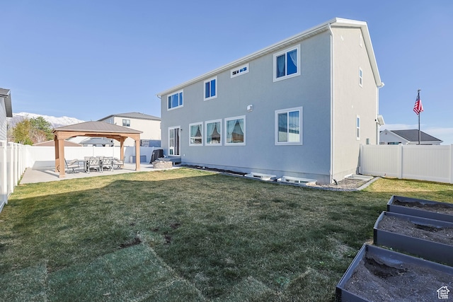 rear view of house featuring a garden, a gazebo, a patio area, and a lawn
