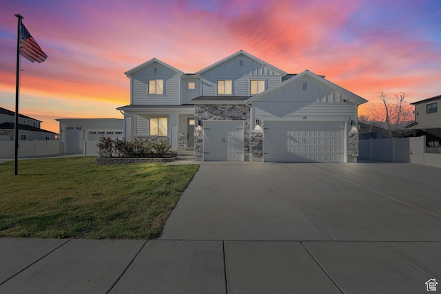 view of front facade featuring concrete driveway, stone siding, a garage, fence, and a lawn