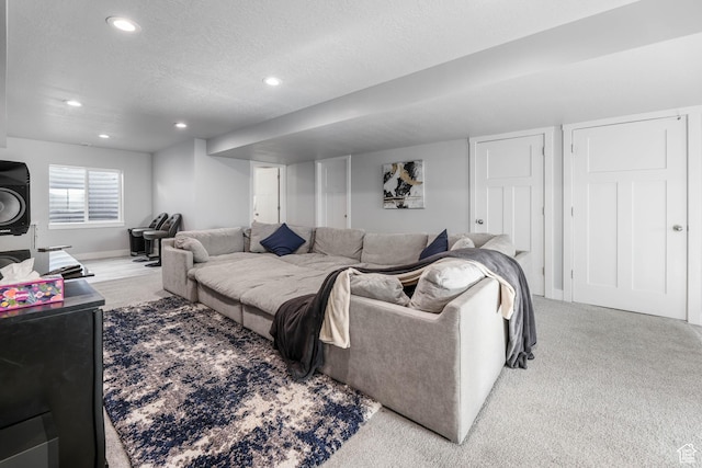 carpeted living area with baseboards, recessed lighting, and a textured ceiling