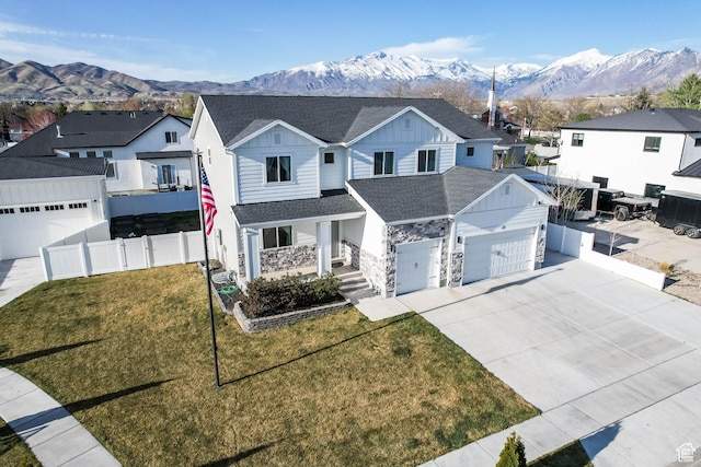 traditional-style house with a residential view, a mountain view, driveway, fence, and a shingled roof