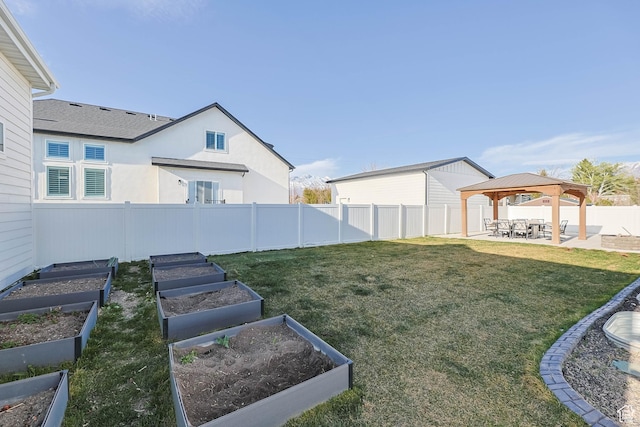 view of yard featuring a patio, a gazebo, fence, and a garden