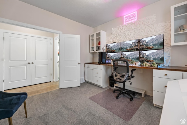 office with built in desk and light carpet