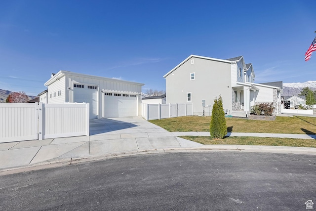 view of front of property featuring a gate, driveway, board and batten siding, a front lawn, and fence