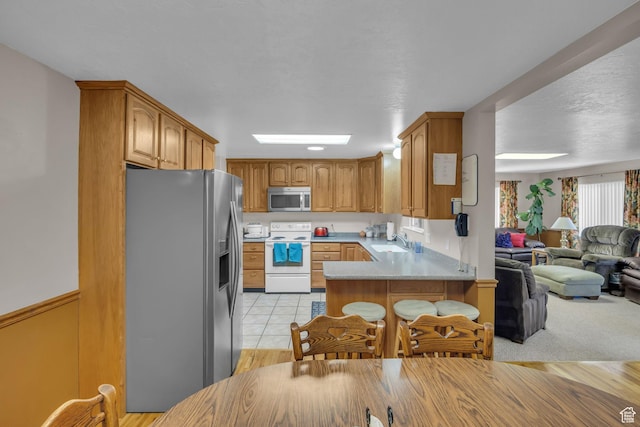 4926 S 3655 W, Taylorsville, UT 84129 - kitchen featuring a sink, open floor plan, light countertops, appliances with stainless steel finishes, and a peninsula
