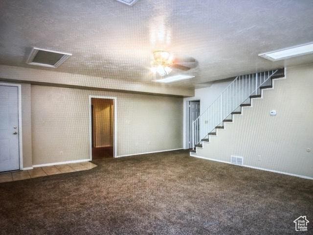 basement with visible vents, baseboards, a ceiling fan, carpet floors, and stairs