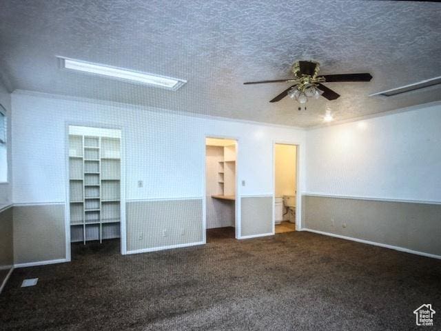 unfurnished bedroom with a spacious closet, carpet flooring, and a textured ceiling