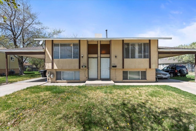 bi-level home with a carport, a front lawn, and brick siding