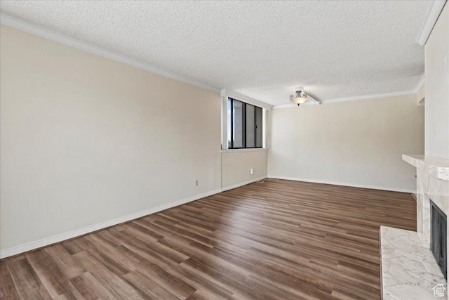 unfurnished living room featuring baseboards, a textured ceiling, crown molding, wood finished floors, and a premium fireplace