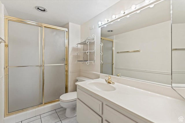 bathroom with a shower stall, tile patterned floors, vanity, and toilet