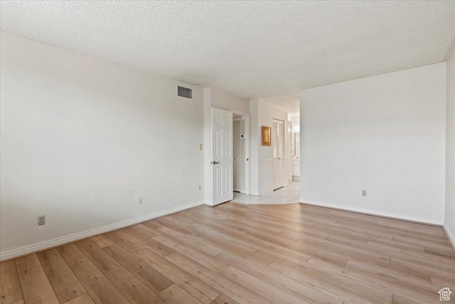 unfurnished room with visible vents, baseboards, and light wood-style flooring
