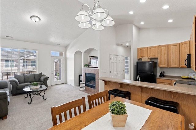 6351 W Traveler Ln, West Jordan, UT 84081 - dining room featuring recessed lighting, visible vents, a chandelier, a tiled fireplace, and light colored carpet