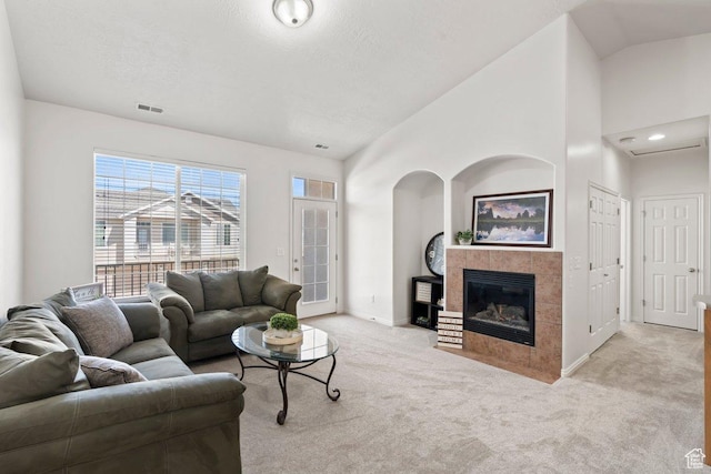 6351 W Traveler Ln, West Jordan, UT 84081 - living room with light carpet, vaulted ceiling, visible vents, baseboards, and a tile fireplace
