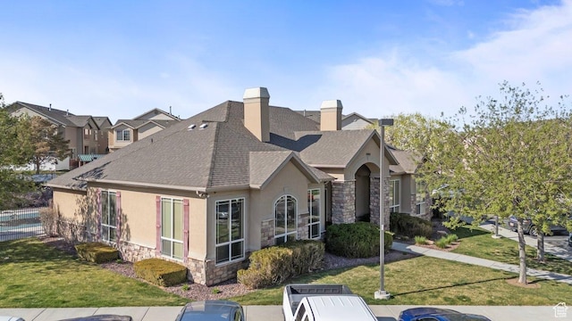 6351 W Traveler Ln, West Jordan, UT 84081 - view of property exterior featuring stone siding, a chimney, a shingled roof, a yard, and stucco siding