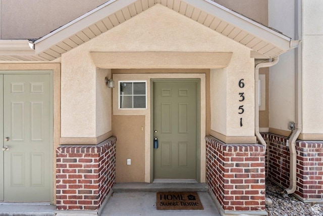entrance to property with stucco siding and brick siding