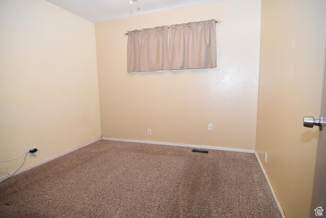 unfurnished room with carpet, visible vents, and baseboards