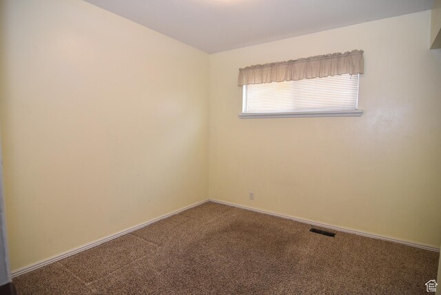 spare room featuring visible vents, baseboards, and carpet floors