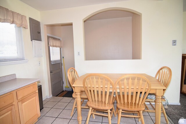 dining area with arched walkways, light tile patterned flooring, and electric panel