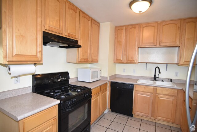 kitchen featuring light countertops, light tile patterned flooring, black appliances, under cabinet range hood, and a sink