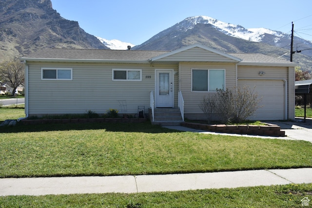 ranch-style home with a mountain view, a garage, concrete driveway, and a front lawn