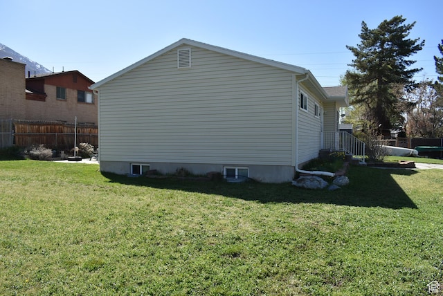 view of side of home featuring a yard and fence