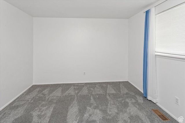 spare room featuring visible vents, baseboards, and carpet floors