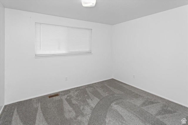 carpeted empty room with visible vents and baseboards