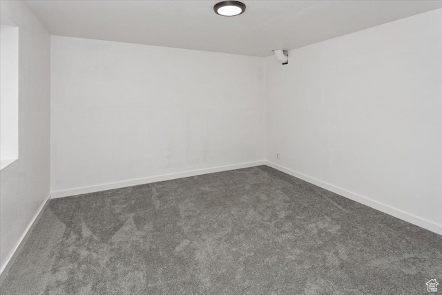 carpeted empty room featuring baseboards