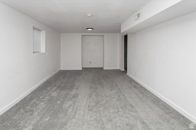 spare room with carpet, visible vents, and baseboards