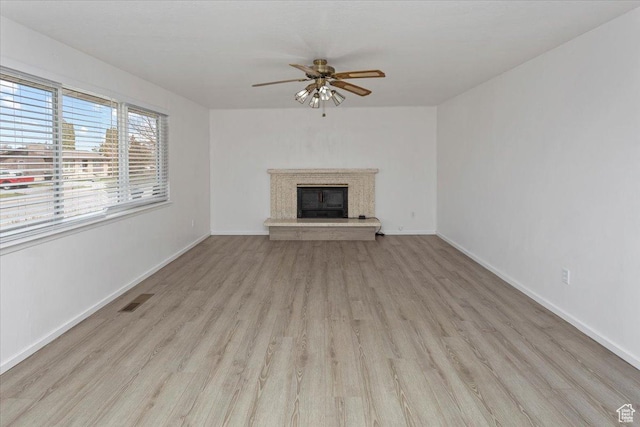 unfurnished living room featuring wood finished floors, baseboards, a ceiling fan, and visible vents