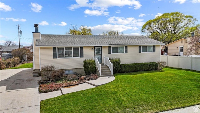 single story home featuring a chimney, fence, and a front lawn