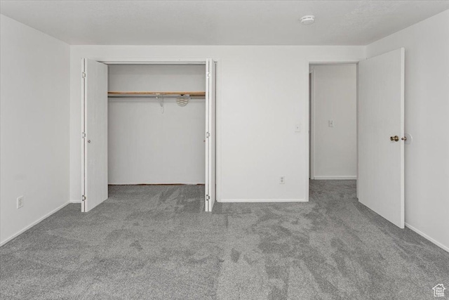 unfurnished bedroom with a closet, baseboards, and carpet floors
