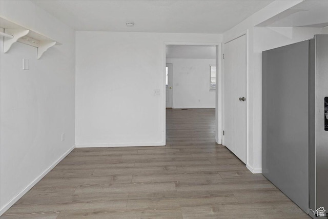 corridor featuring baseboards and wood finished floors