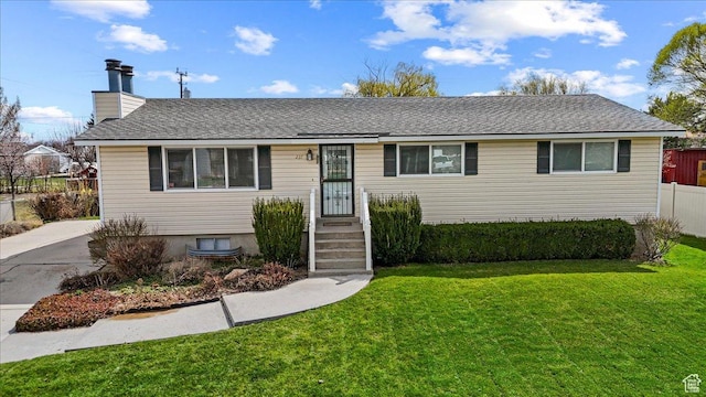 single story home with a chimney, fence, and a front lawn