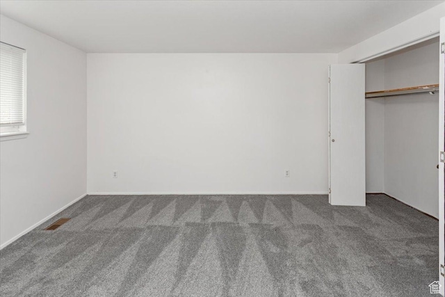 unfurnished bedroom with a closet, carpet flooring, baseboards, and visible vents