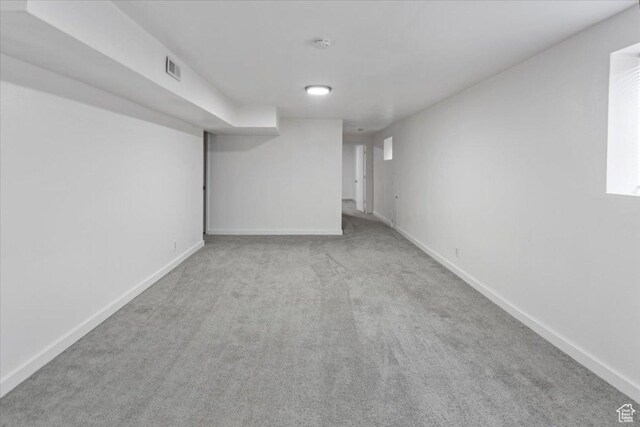 finished below grade area with carpet flooring, baseboards, and visible vents