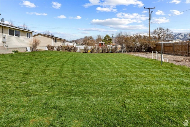 view of yard with fence and a playground