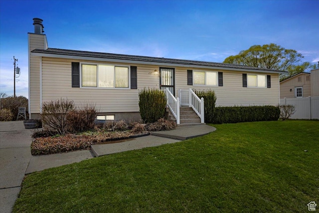 ranch-style house featuring a front yard and fence