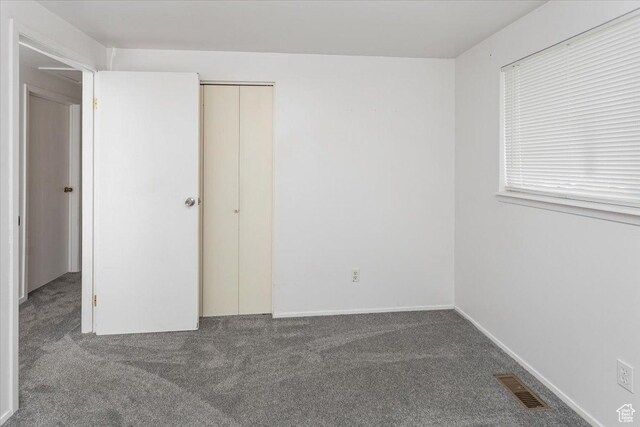 unfurnished bedroom featuring visible vents and carpet
