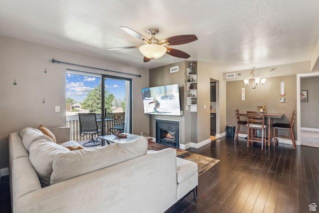 living area featuring visible vents, baseboards, a textured ceiling, and ceiling fan with notable chandelier