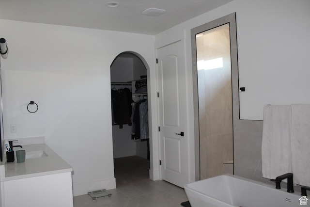 2892 E 1400 S, St George, UT 84790 - bathroom with vanity, a freestanding tub, a walk in closet, and tile patterned floors
