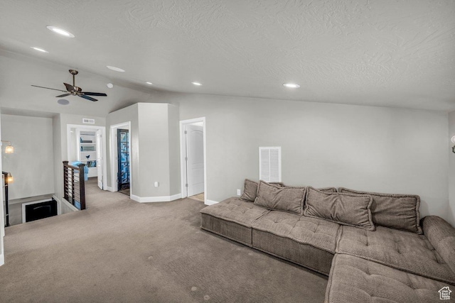 carpeted living area featuring baseboards, vaulted ceiling, a textured ceiling, a ceiling fan, and visible vents