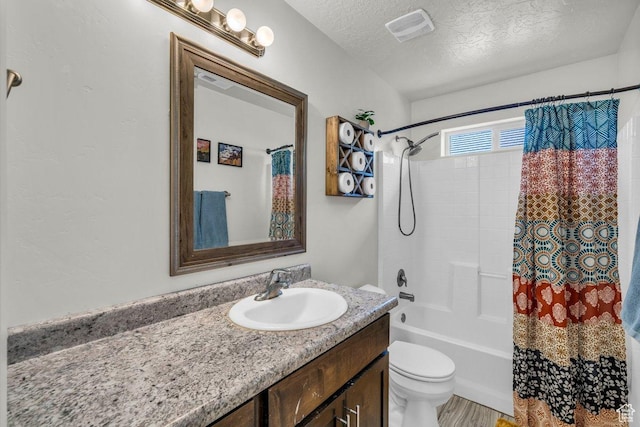 bathroom with vanity, shower / tub combo with curtain, a textured ceiling, toilet, and visible vents