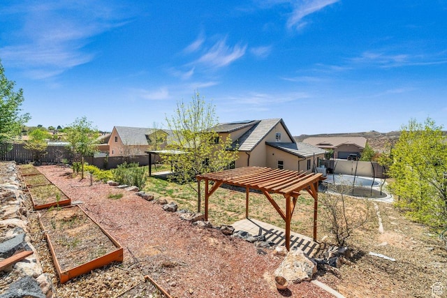 view of yard with a garden, a pergola, and a fenced backyard