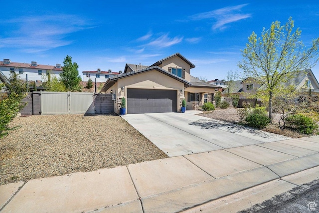 traditional home with an attached garage, fence, a gate, and concrete driveway