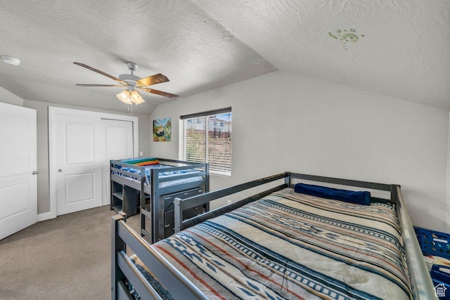 carpeted bedroom featuring a textured ceiling, baseboards, a ceiling fan, and lofted ceiling