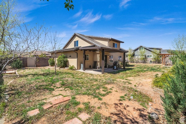 back of house featuring a fenced backyard, a patio, and stucco siding