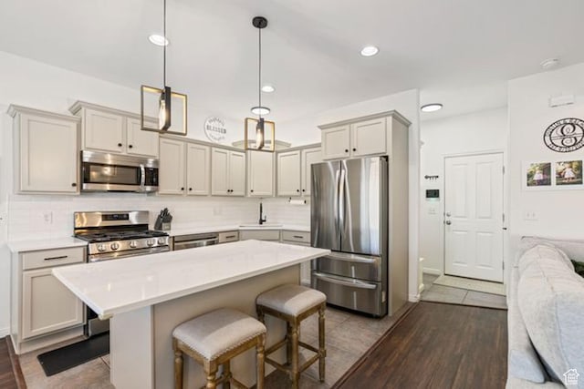 896 W Waterside Dr, Farmington, UT 84025 - kitchen featuring a breakfast bar, light countertops, backsplash, and stainless steel appliances