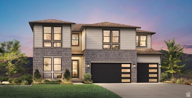 view of front of property with stone siding, an attached garage, and concrete driveway