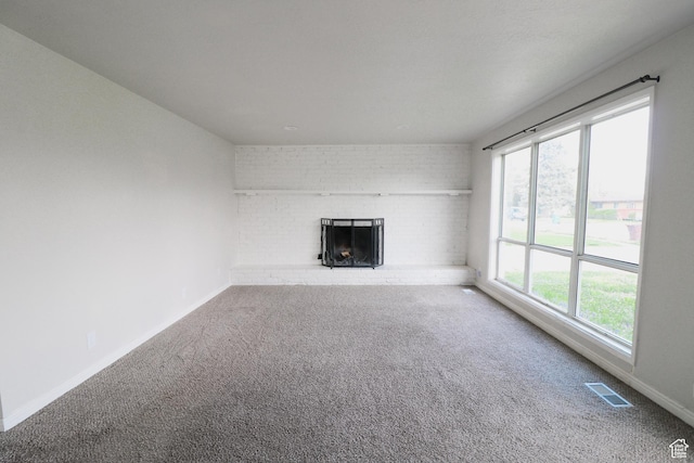 4503 S 2025 W, Roy, UT 84067 - unfurnished living room with a brick fireplace, baseboards, carpet flooring, and visible vents